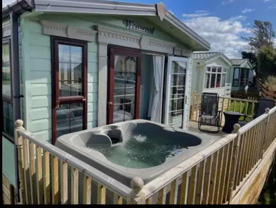a hot tub on the deck of a house at 'Sunset Lodge' Peaceful Coastal Retreat with Hot Tub in Monreith