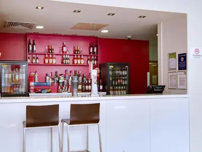 a bar with two chairs and a red wall at Travelodge Carlisle Central in Carlisle