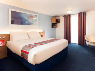 a bedroom with a large bed in a hotel room at Travelodge Carlisle Central in Carlisle