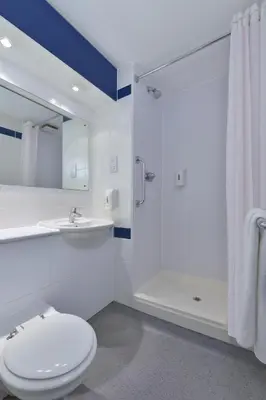 a bathroom with a toilet and a sink and a shower at Travelodge Carlisle Todhills in Rockcliffe