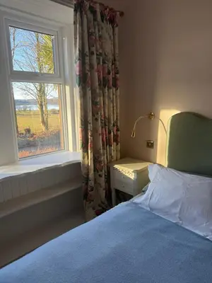 a bedroom with a bed and a window at Skinnel Cottage in Kirkcudbright