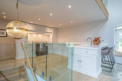 a kitchen with a glass counter and a sink at Luxurious Barn within easy reach of South Lakes! in Boot