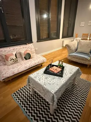 a living room with a table and a couch at Flat in the heart of Liverpool city centre in Moffat