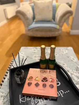 two bottles of wine on a table with a book at Flat in the heart of Liverpool city centre in Moffat