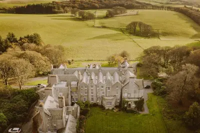 an aerial view of a large mansion in a field at Castle Penthouse on Estate by the Sea in Enoch