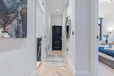 a hallway with a black door and a bedroom at Central Jewellery Quarter 1-Bedroom with Parking in Moffat