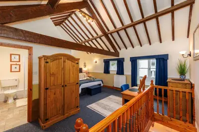 a living room with a staircase leading to a bedroom at Stables Cottage - Wythop Mill in Embleton
