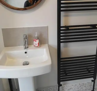 a bathroom with a sink and a mirror and a shelf at Double rooms in Moffat