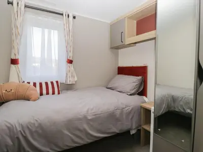 a small bedroom with two beds and a window at Guillemot in St Bees