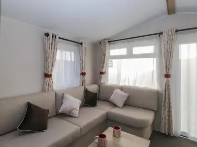 a living room with a couch and two windows at Guillemot in St Bees