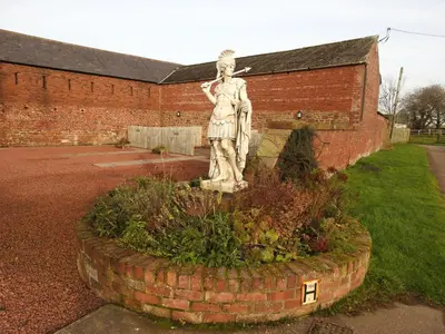 a statue of a woman standing in a garden at Milecastle, Irthington on Hadrians Wall in Irthington