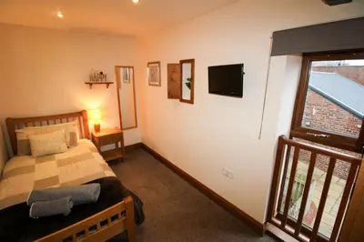 a bedroom with a bed and a television on the wall at Milecastle, Irthington on Hadrians Wall in Irthington