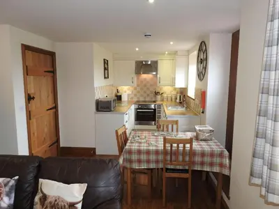 a kitchen with a table and chairs and a kitchen with a table and a couch at Stanegate, Irthington on Hadrians Wall in Irthington