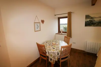 a dining room with a table and chairs and a window at Turret, Irthington on Hadrians Wall in Irthington