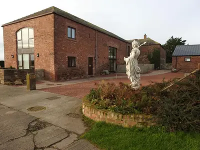 a statue of a woman in front of a brick building at Vallum, Irthington on Hadrians Wall in Irthington