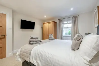 a bedroom with a large white bed and a television at 2 Bed in Gretna Green oc-n34146 in Gretna Green