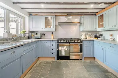 a kitchen with blue cabinets and an oven at 6 Bed in Low Moresby oc-l34667 in Distington