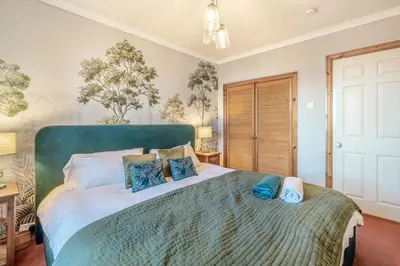 a bedroom with a large bed with blue pillows at 6 Bed in Low Moresby oc-l34667 in Distington