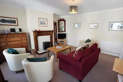 a living room with two chairs and a red couch at Riverside Heights- Dog Friendly Lakeland Retreat in Town Centre in Cockermouth