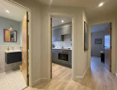 a kitchen with a door open to a room with a sink at Catbells in Keswick