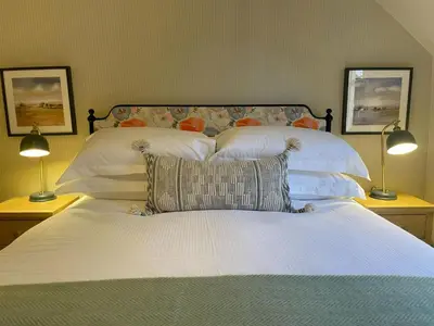 a bed with white pillows and two lamps at Catbells in Keswick