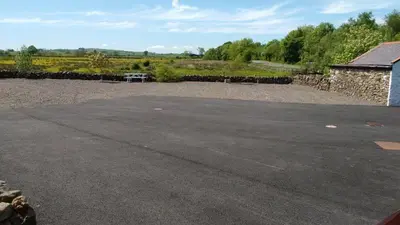 a parking lot with a picnic table in a field at Cargenbank Farmhouse in Lochfoot