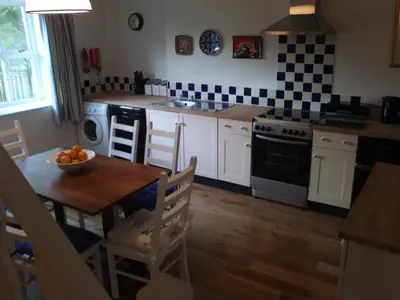 a kitchen with a table with a bowl of fruit on it at Cargenbank Farmhouse in Lochfoot