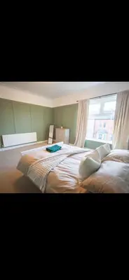 a bedroom with two beds and a large window at Comfortable Carlisle Stay with Free Parking in Carlisle