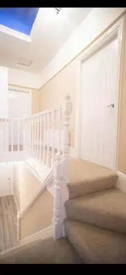 a white staircase in a home with a white door at Comfortable Carlisle Stay with Free Parking in Carlisle