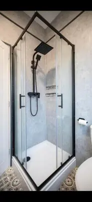 a shower with a glass door in a bathroom at Comfortable Carlisle Stay with Free Parking in Carlisle