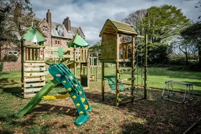 a playground with a slide and a play structure at The Old Vicarage Irton in Parton