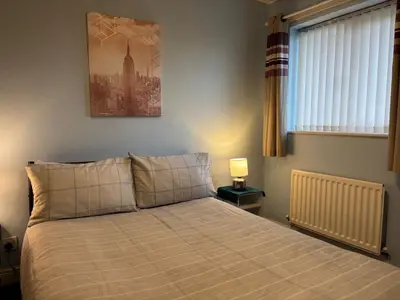 a bedroom with a bed and a picture on the wall at 1-Bed Suburban Carlisle Terraced Home with Parking in Carlisle