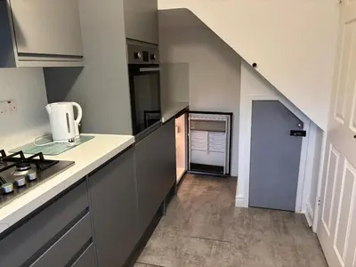 a kitchen with gray cabinets and a stairway at 1-Bed Suburban Carlisle Terraced Home with Parking in Carlisle