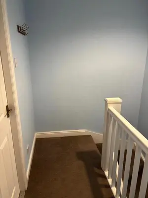 a hallway with a stairway with a blue wall at 1-Bed Suburban Carlisle Terraced Home with Parking in Carlisle