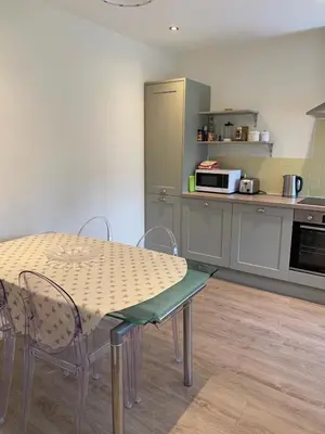 a kitchen with a table and chairs and a microwave at Bee Cottage in Moffat