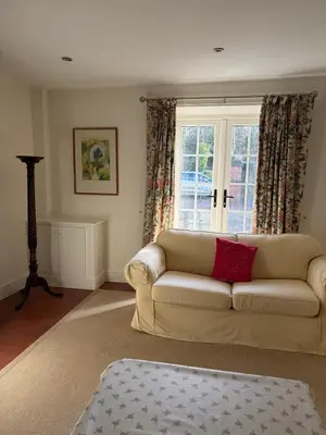a living room with a couch and a window at Bee Cottage in Moffat