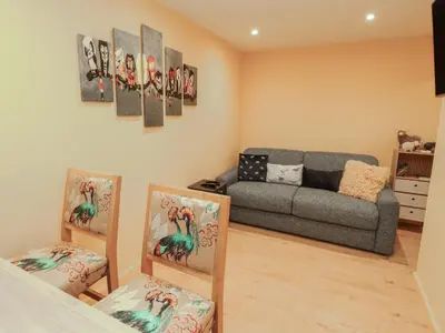 a living room with a couch and paintings on the wall at The Nook in Wigton