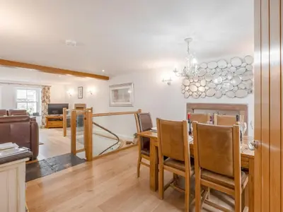 a dining room and living room with a table and chairs at Mary's Cottage in Keswick