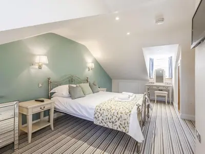 a bedroom with a large bed and a desk at Mary's Cottage in Keswick