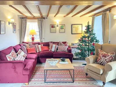 a living room with a purple couch and a christmas tree at Crofthead in Hesket Newmarket