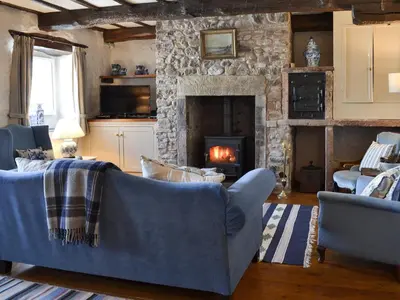 a living room with a couch and a fireplace at Branthwaite Stable in Caldbeck