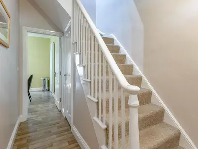 a staircase with white railings in a home at Jame's Cottage in Keswick