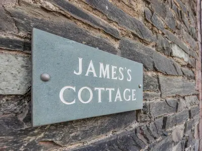 a sign on the side of a brick wall at Jame's Cottage in Keswick