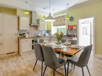 a kitchen with a dining room table and chairs at Jame's Cottage in Keswick