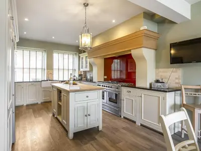 a large kitchen with white cabinets and a sink at Mount Pleasant in Threlkeld