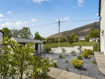 a garden with a house and mountains in the background at Mount Pleasant in Threlkeld