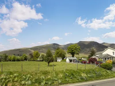 a view of a field with mountains in the background at Mount Pleasant in Threlkeld
