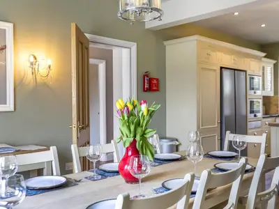 a dining room with a table with a vase of flowers at Mount Pleasant in Threlkeld