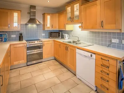 a kitchen with wooden cabinets and a stove top oven at Tanglewood in Whiting Bay