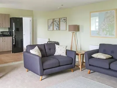 a living room with two chairs and a couch at Dairy Cottage in Girvan